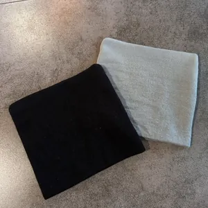 Detailed view of black and light grey-green knitted cat ear hats with fine textures