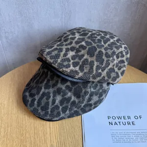 Detail of vintage leopard print ivy caps with premium leather trim on wooden stool