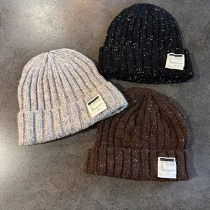 Three warm knit beanies in black, grey and coffee with white snowflake texture and label