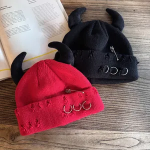 Distressed knit beanies with devil horns, safety pins, and metal rings in black and red