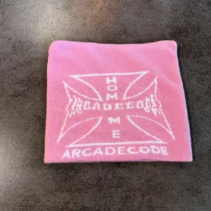 Detailed knit texture of pink cat-ear beanie featuring white jacquard letter patterns