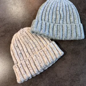 Chunky ribbed knit beanies in light blue and beige colors, cozy winter ear protection style