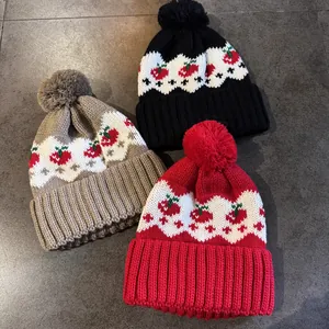 Berretti in maglia Fair Isle con motivi a ciliegia rossa e pompon in rosso, nero e beige