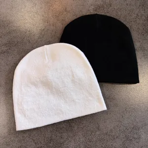 Nahaufnahme der schwarz-weißen Strickmützen zeigt weiche Textur und elastisches Gewebe