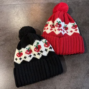 Berretto in maglia Fair Isle con motivo jacquard ciliegia e pompon in rosso e nero