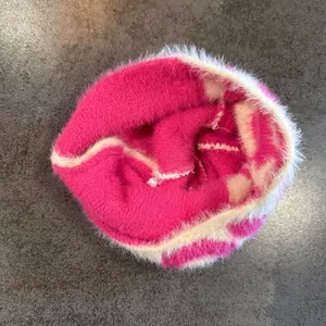 Detail of soft faux mohair knitted hat featuring vibrant fuchsia and white contrast colors