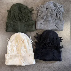 Gorros de punto desgastados en cuatro colores con detalles rotos y flecos largos