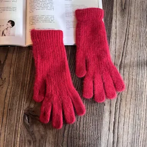 Detailed close-up of thick rose red rabbit fur knit gloves with warm ribbed cuffs