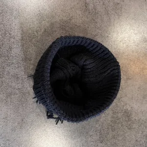 Primer plano de gorro de punto negro que muestra textura de canalé grueso y tejido cálido