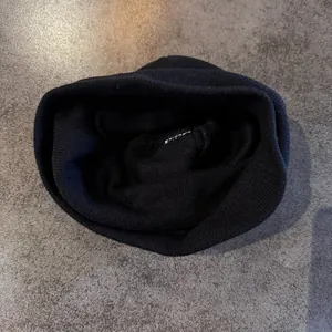 Detailed inner view of black ribbed knit beanie showing soft textured fabric lining