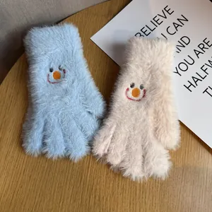 Détail de la broderie smiley sur des gants d'hiver en peluche douce pour femmes