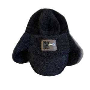 Bonnet tricoté d'hiver noir avec doublure en fausse fourrure et écusson en cuir K