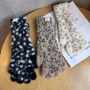 Schicke Leoparden-Plüsch-Strickhandschuhe in drei Farben auf einem Holztisch