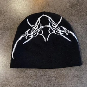 Vue détaillée de dessus d'un bonnet en maille noir avec motif jacquard d'os style hip-hop