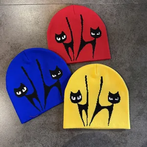 Detaillierte Strickstruktur farbiger Mützen mit minimalistischem Schwarz-Weiß-Katzen-Jacquard