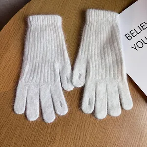 Detailed macro view of white cable knit gloves featuring touch-screen fingertip openings