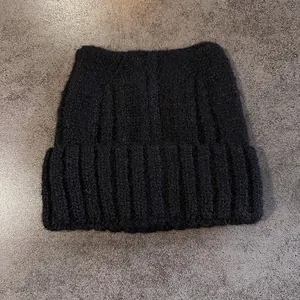 Dettaglio del berretto nero in maglia con orecchie da gatto e morbida texture mohair