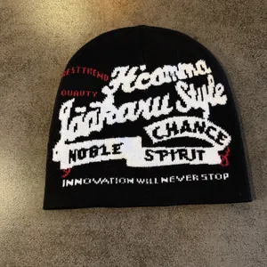 Détail du bonnet en maille style urbain noir avec motifs graphiques jacquard rouge et blanc