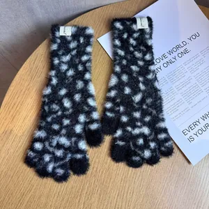 Nahaufnahme von Plüsch-Strickhandschuhen mit Leopardenmuster und weicher Textur