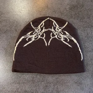 Gros plan détaillé du bonnet en tricot marron foncé avec motifs jacquard tribaux blancs