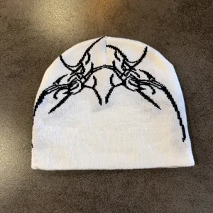 Détail de la texture tricotée du bonnet blanc gothique avec motif jacquard noir