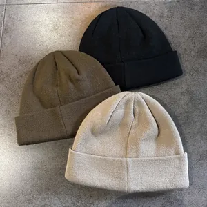 Drie minimalistische gebreide mutsen in zwart, olijfgroen en beige voor de winterwarmte