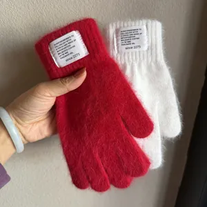 Detail of red and cream plush rabbit fur knit gloves with stylish woven labels