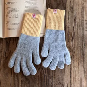 Nahaufnahme grauer und gelber Strickhandschuhe mit weicher Textur und indie-Markenetikett