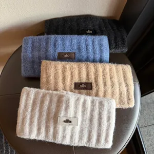 Detail of four knitted headbands in grey blue camel and beige with leather patch