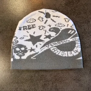 Detailed knit texture of the gray beanie with white jacquard skulls and stars patterns