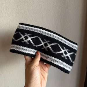 Detailansicht eines ethnischen Strickstirnbands mit warmem grauem Rautenmuster