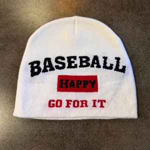 Close-up of white knitted beanie featuring black and red jacquard lettering and texture