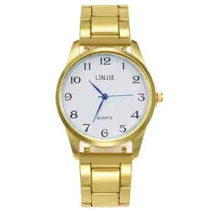 Détail du cadran blanc texturé avec aiguilles bleues et bracelet en acier doré de la montre
