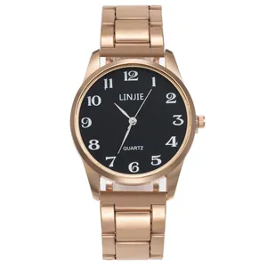 Gros plan d'une montre à quartz en acier or rose avec cadran noir et chiffres blancs