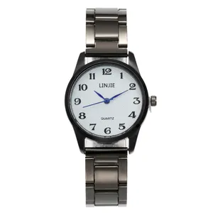 Détail d'une montre à quartz avec aiguilles bleues et bracelet en métal foncé