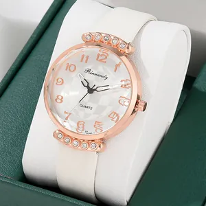 Detailed close-up of rose gold quartz watch with rhinestones on a white cushion