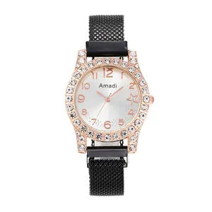 Détail de montre or rose avec strass, cadran étoilé et bracelet magnétique