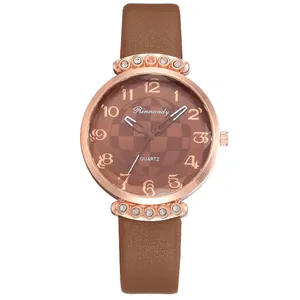 Detail of a brown leather strap watch with rose gold case and sparkling rhinestones