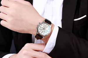 Detail of classic men's business watch with white dial and black leather strap worn with suit