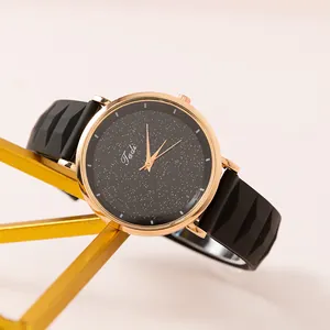 Montre femme ciel étoilé avec bracelet silicone noir et boîtier or rose sur support
