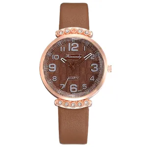 Detailed macro view of the rose gold rhinestone case and brown leather strap watch
