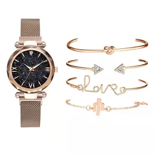 Detail of rose gold mesh watch with starry blue dial and four assorted charm bracelets