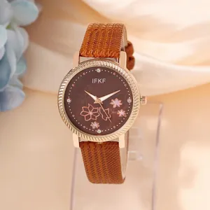 Elegant women's watch with brown floral dial, rose gold case and leather strap on silk background