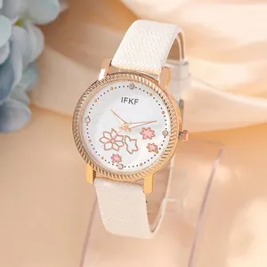 Detail of white leather watch strap and rose gold dial with pink cherry blossom pattern