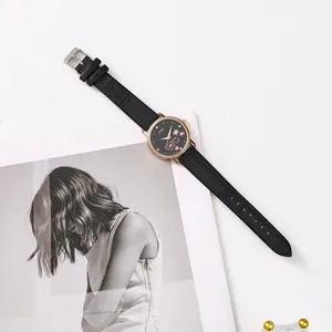 Detail of rose gold watch case with pink cherry blossom pattern on a black dial