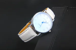 Detail of white leather watch strap and silver Roman numeral dial with blue hands