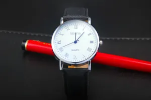 Macro shot of a classic quartz watch with Roman numerals and black leather strap textures