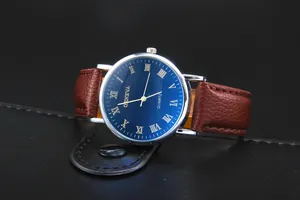 Detail of blue sunray dial with Roman numerals and brown leather strap of the quartz watch