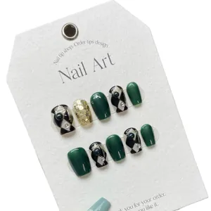 Handmade emerald green press-on nails with checkered patterns and golden glitter accents