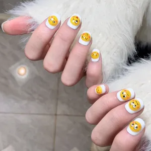 Cute white short round press-on nails with yellow emoji face designs on fuzzy background